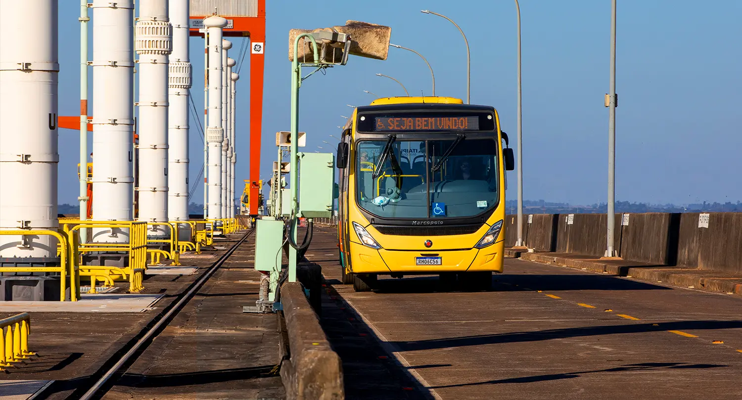 Yellow bus passing by the top of the Itaipu Hydroelectric Plant dam, located in Foz do Iguaçu.